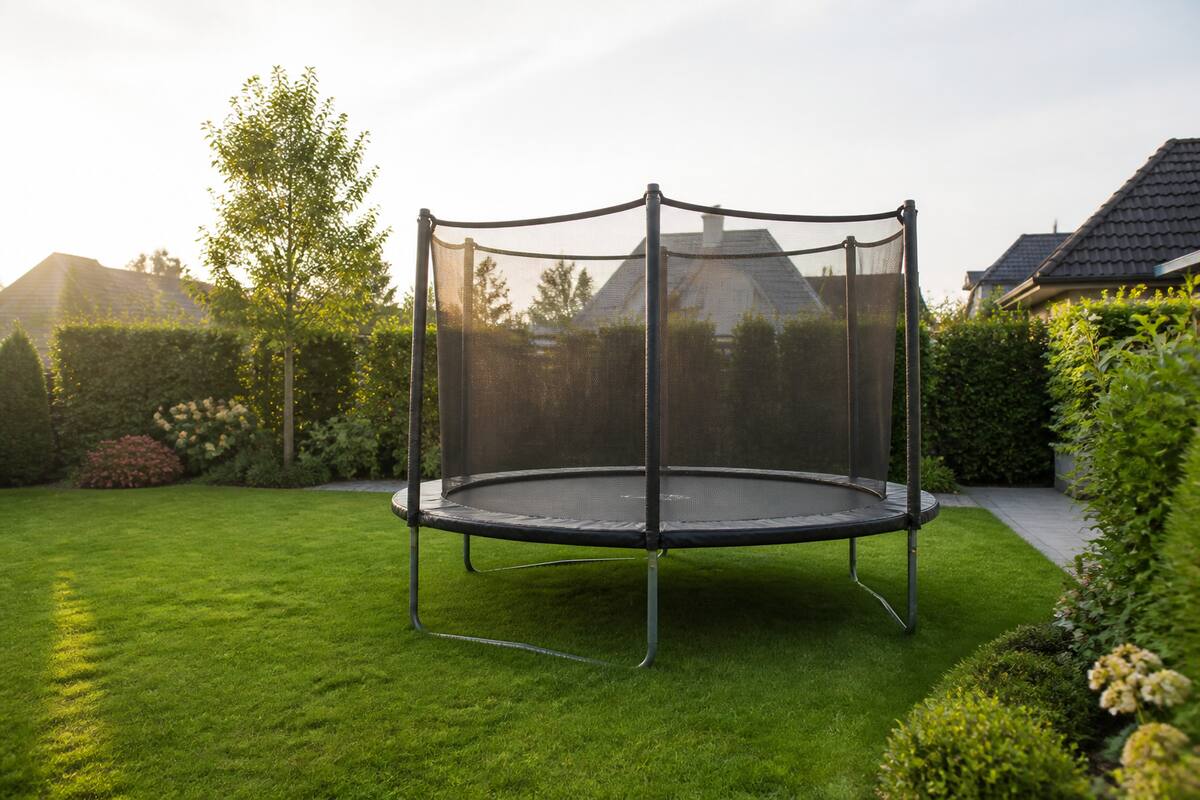 Trampoline met veiligheidsnet in een ruime achtertuin